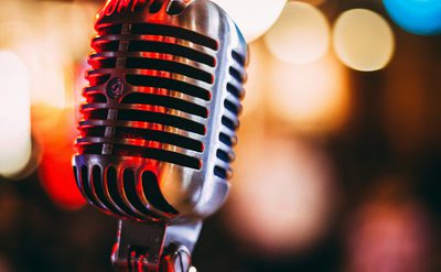 A old fashioned microphone with stage lit backdrop