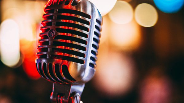 A old fashioned microphone with stage lit backdrop