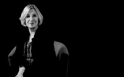 A black-and-white photo of a woman sitting calmly in a chair.
