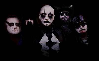 Five people in gothic-style costumes and dramatic makeup posing together.