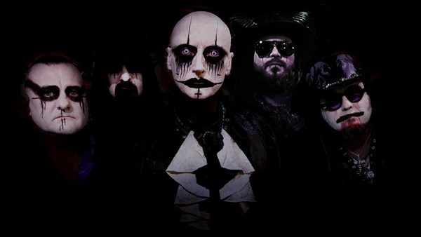 Five people in gothic-style costumes and dramatic makeup posing together.